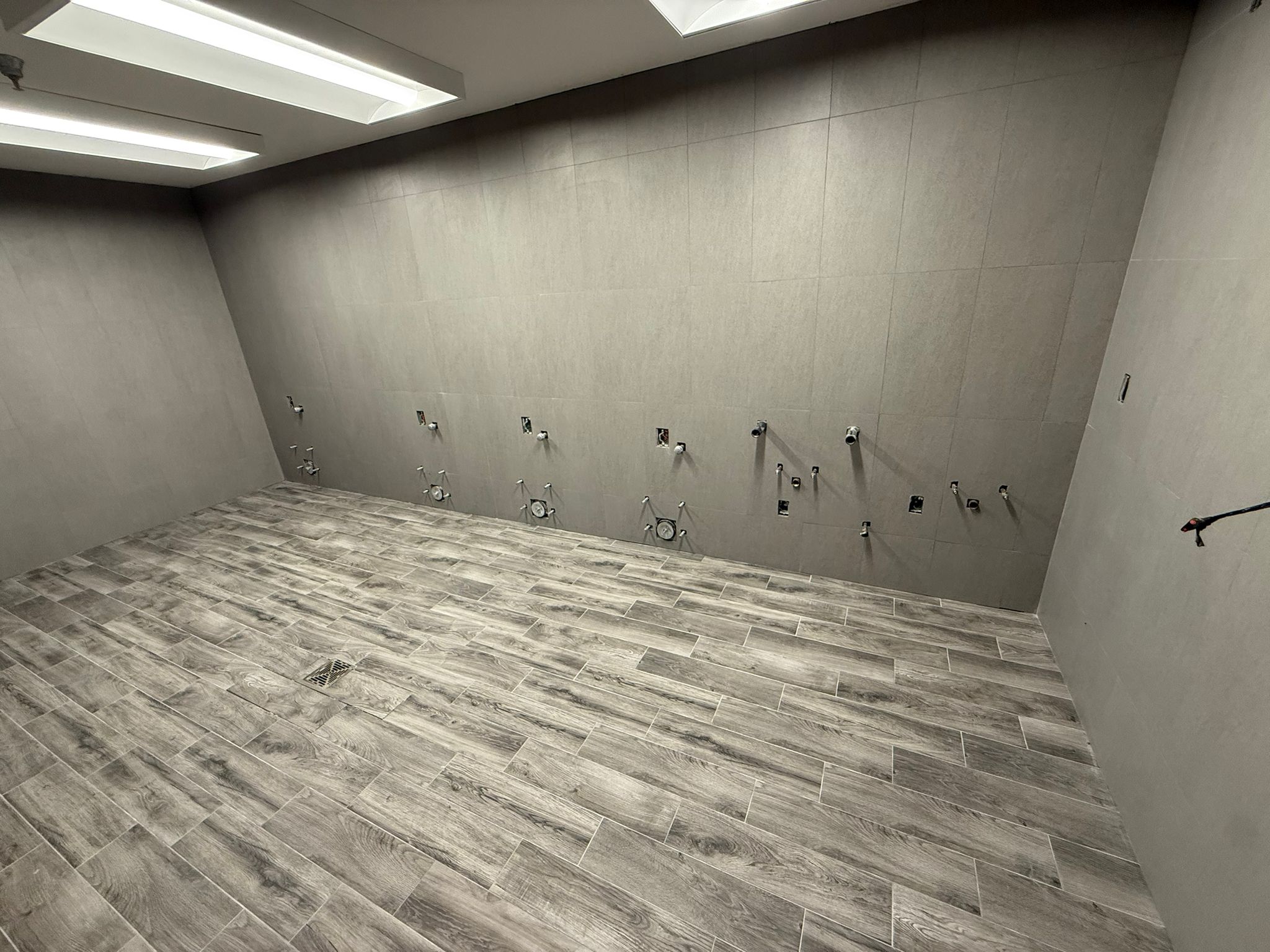 Wood-look wall and floor tile installation with large gray wall tile
