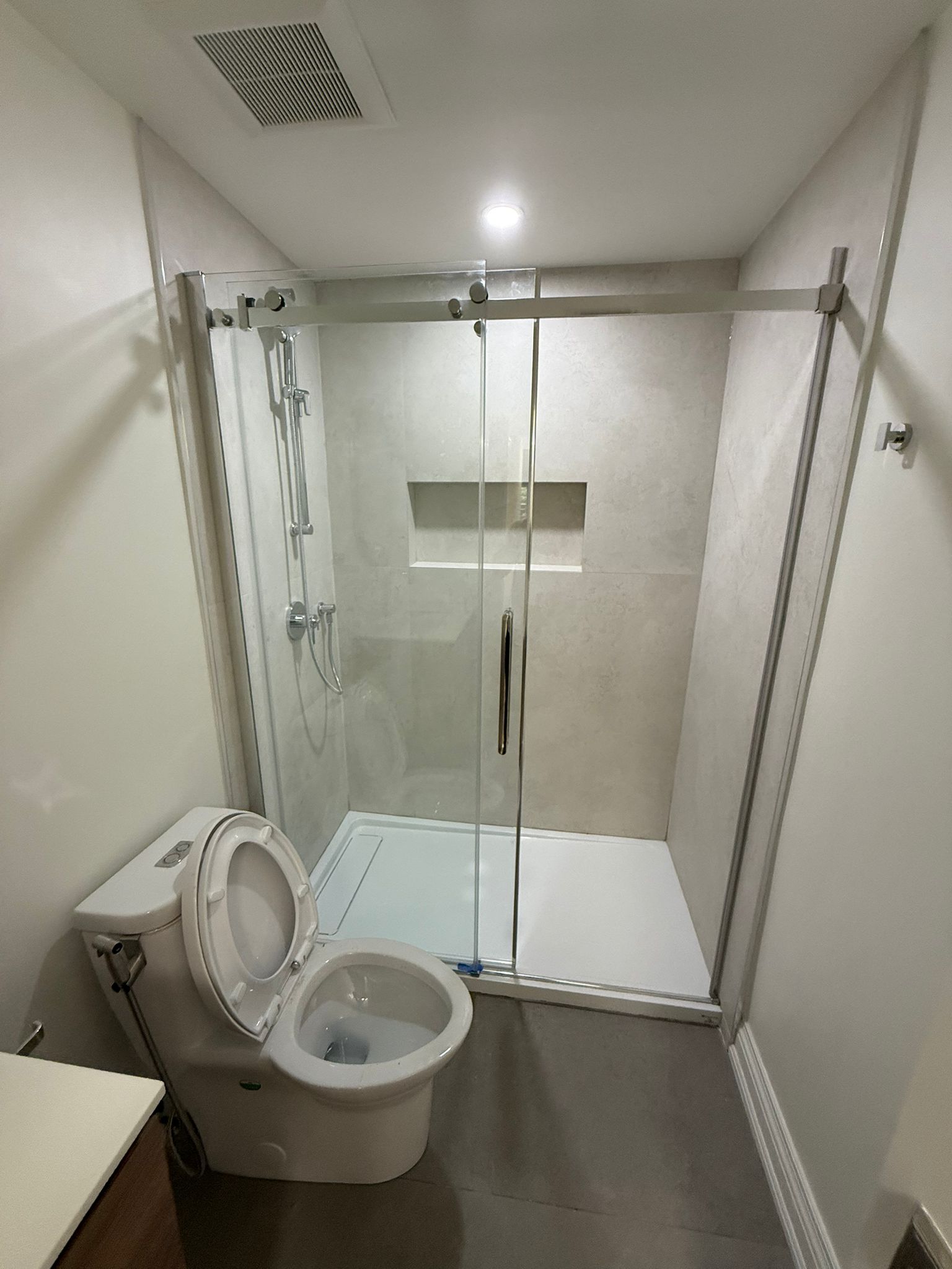 Finished washroom renovation with glass shower doors and new fixtures