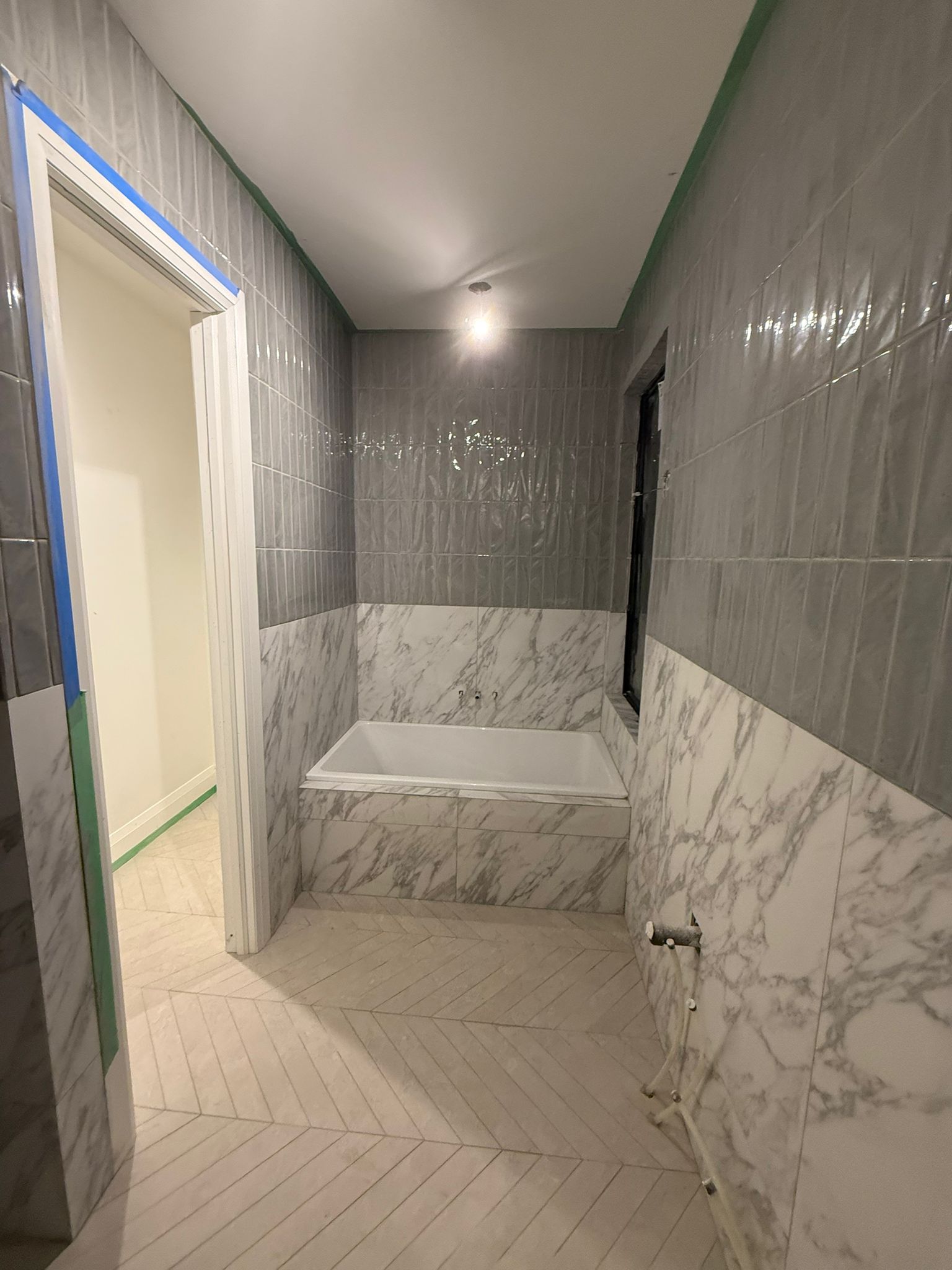 Washroom renovation with marble-look floor tile and gray wall tile